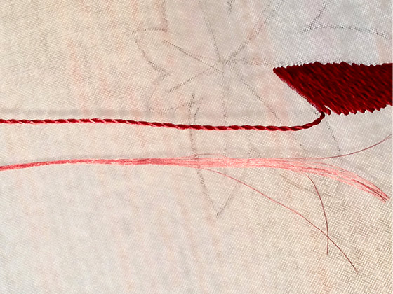 上が撚りをかけた糸。 下が繭から取り出した絹糸10本の束の釜糸。